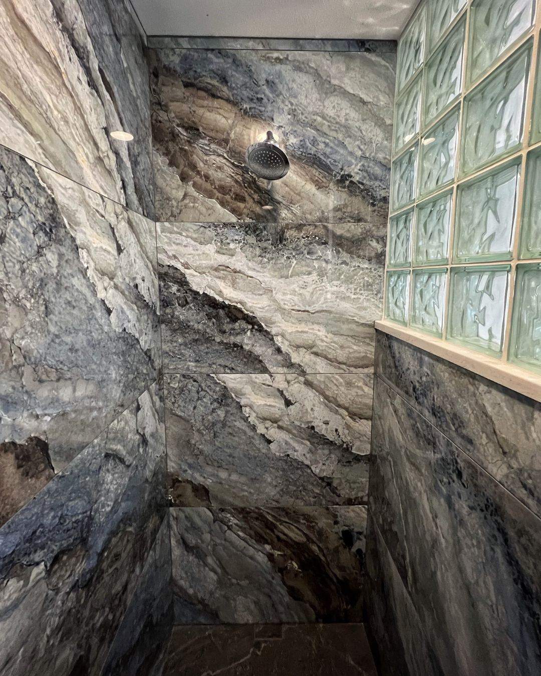 Custom marble slab shower installation by Quintessence Tile & Stone LLC